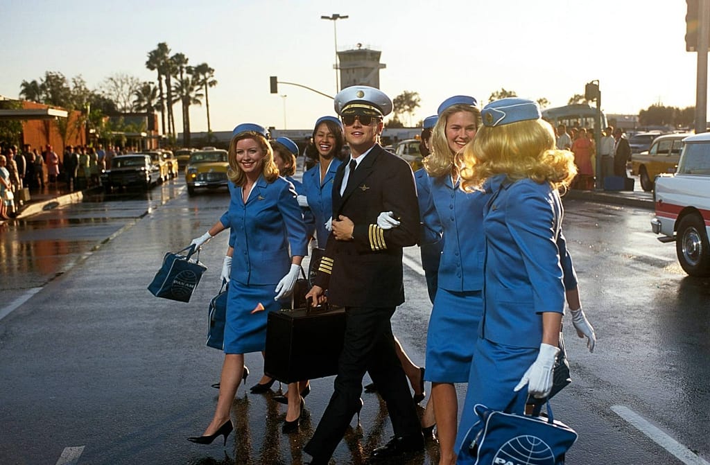Leonardo DiCaprio en uniforme de pilote, entouré d’hôtesses de l’air Pan Am, dans le film Arrête-moi si tu peux (Catch Me If You Can, 2002) de Steven Spielberg